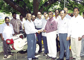TAN Thenappan seen handing over the starting hand crank of the tiller to R Subramanian, Executive Engineer PWD, Mettur.